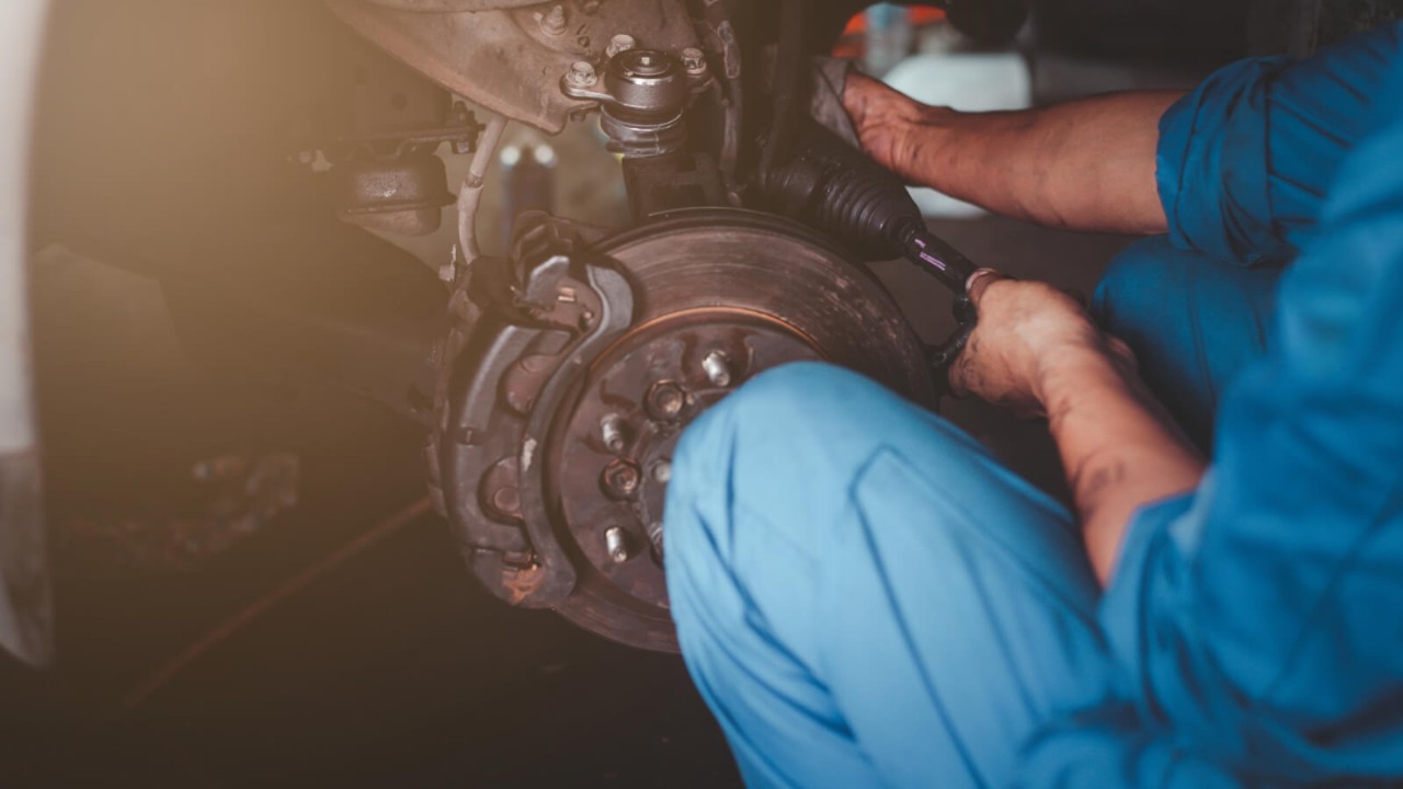 Mechanik naprawiający łożysko w kole samochodu